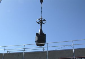 heavy piece of equipment suspended by crane in New Haven, CT